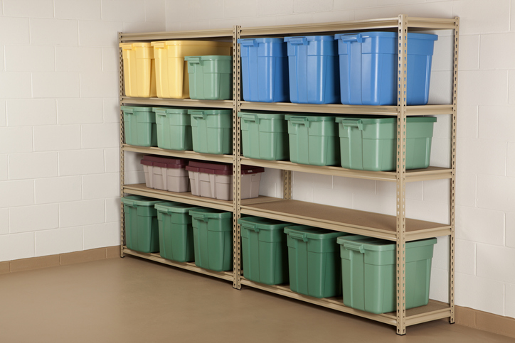 green-and-blue-and-yellow-plastic-storage-boxes-with-lids-on-a-metal-shelving-unit-in-a-basement