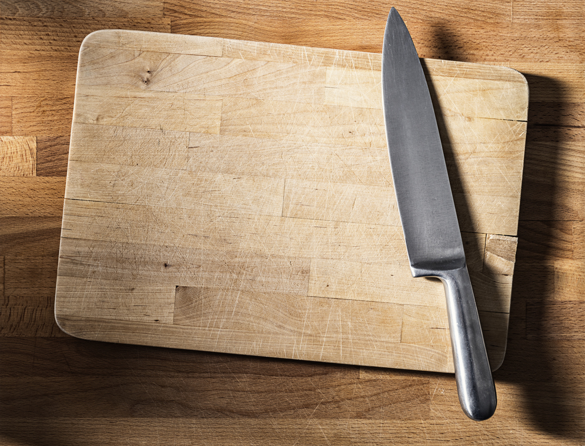 stainless steel knife on cutting board on top of woodblock counter