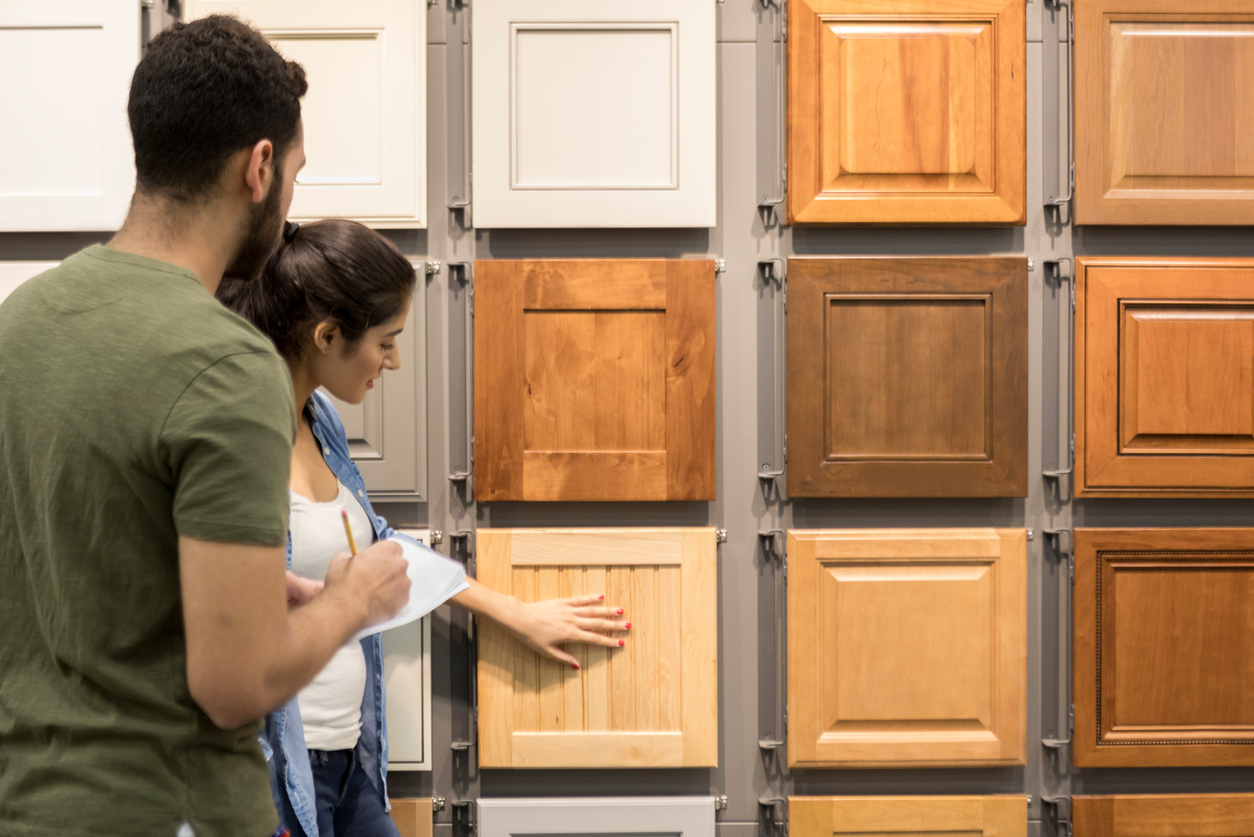Young couple look at cabinet samples in home improvement store