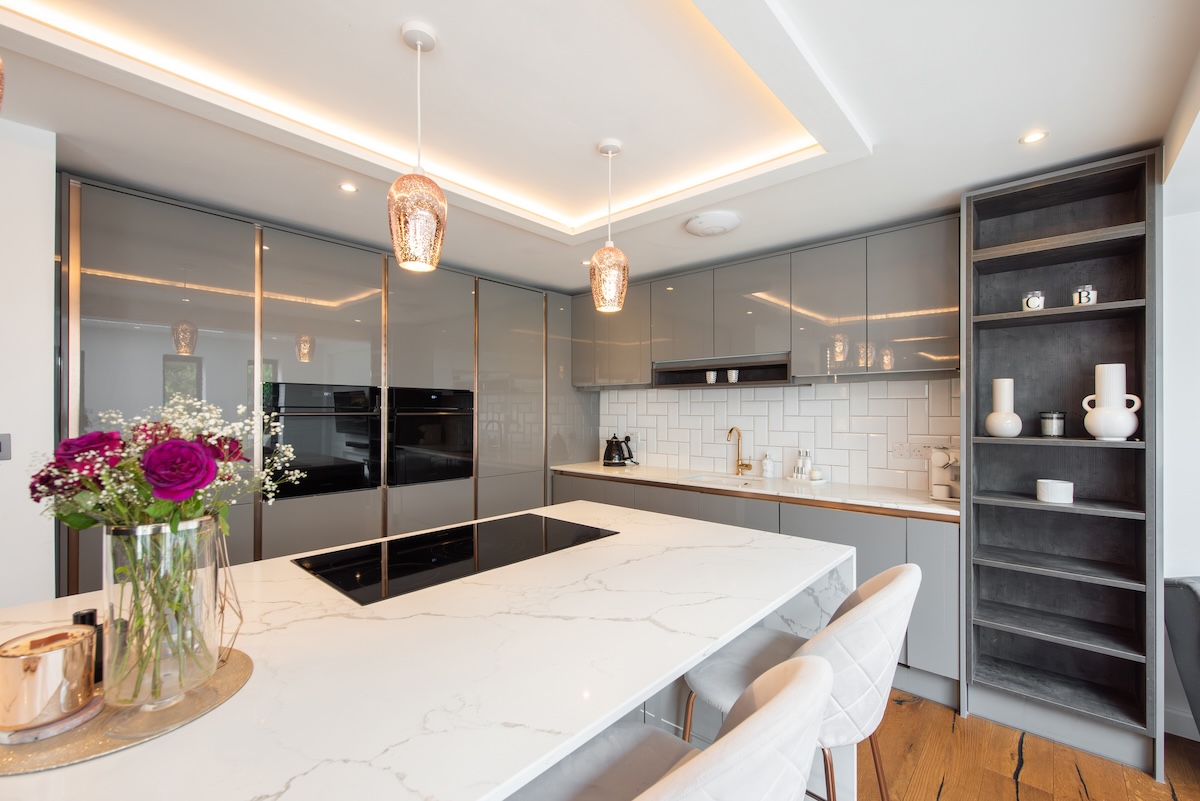 A modern luxury kitchen with a white interior and porcelain countertops.