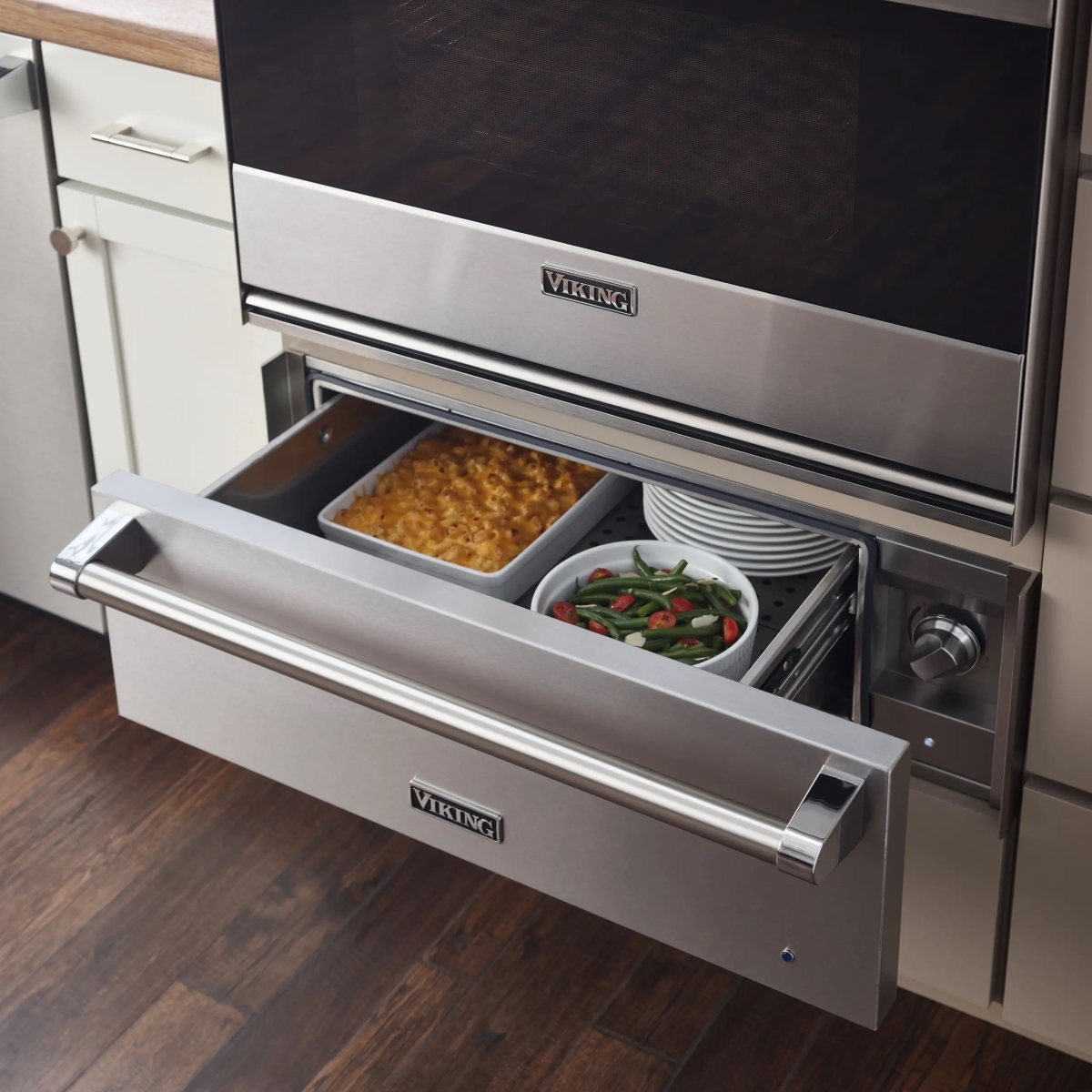 Silver oven warming drawer with dishes of food