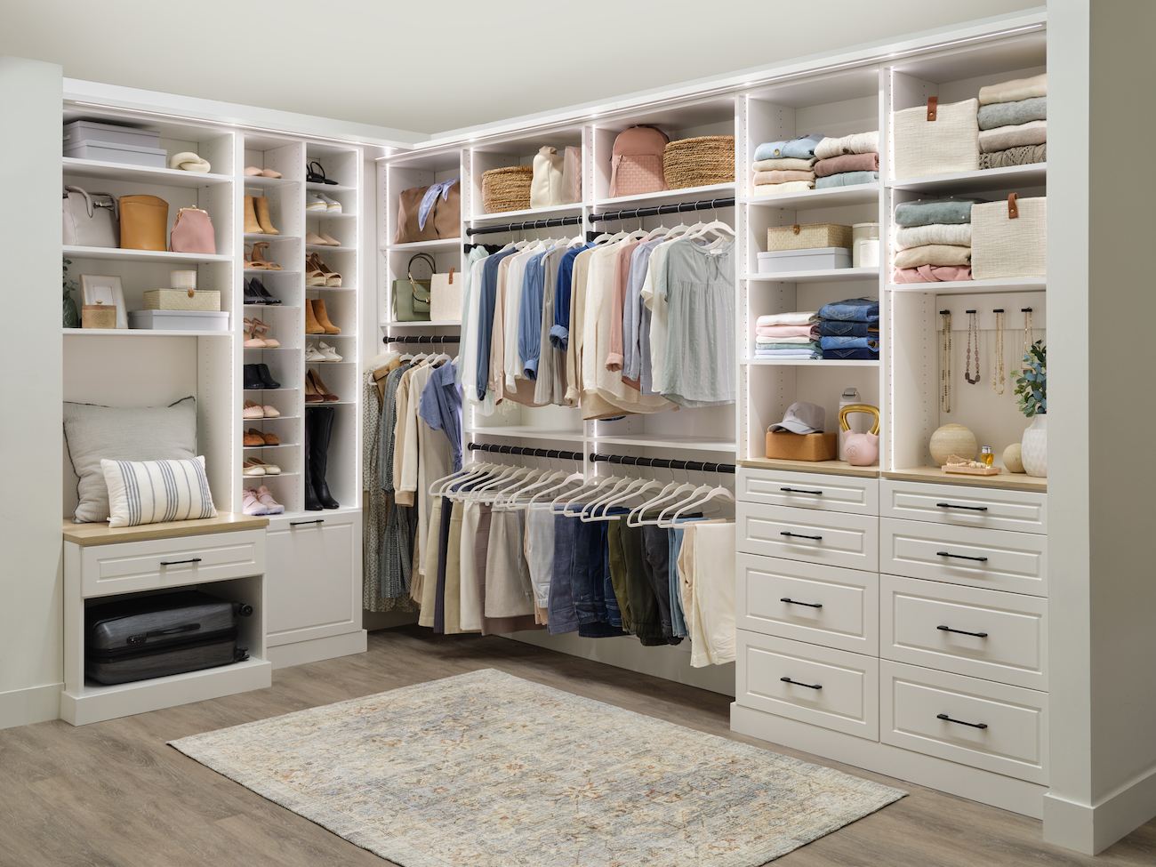Ladies' walk-in closet with cream-colored shelving and cabinetry