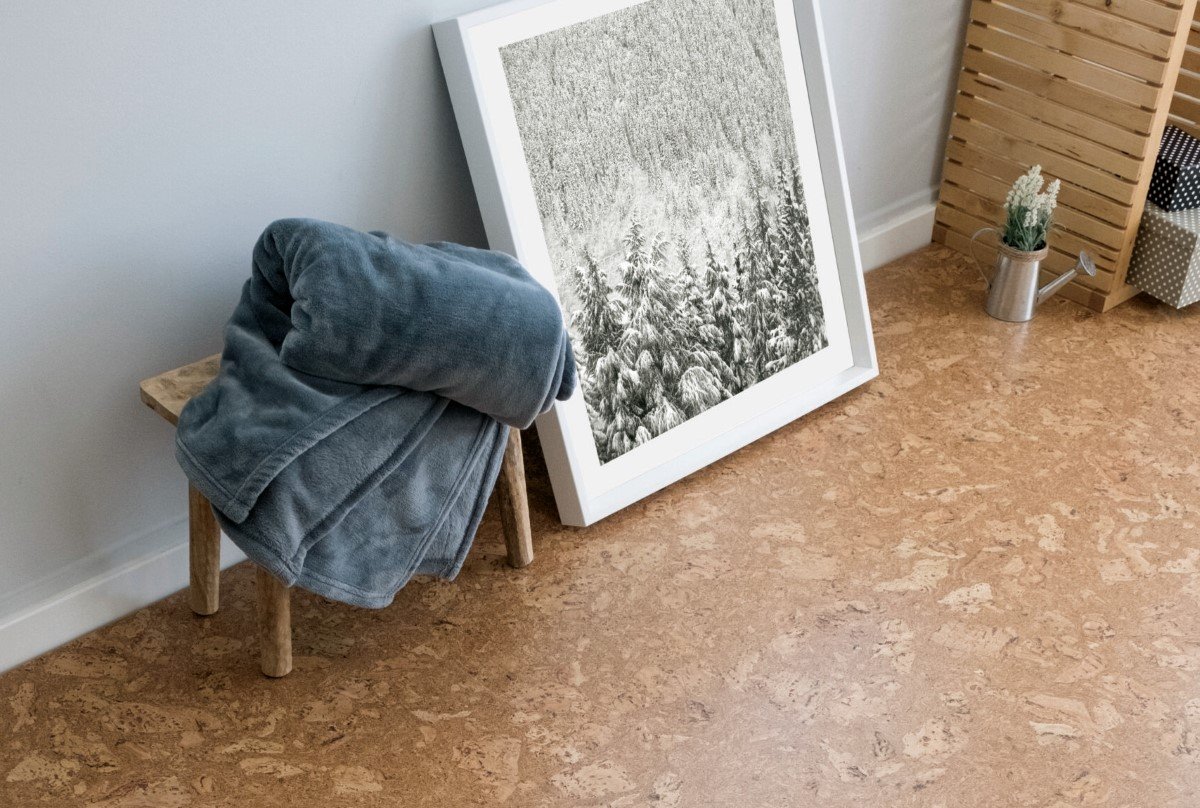 A towel on a stool in a bathroom with cork flooring.