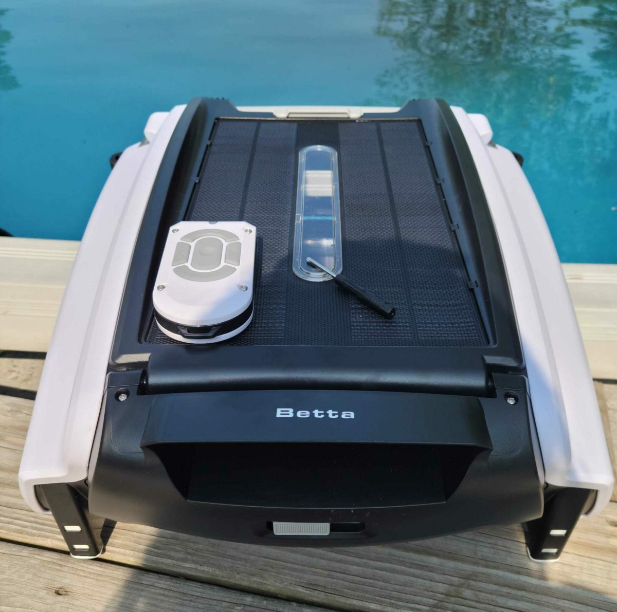 BettaBot robotic pool skimmer on deck next to pool