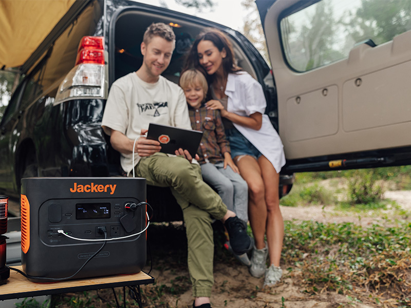 Family charging a tablet while camping