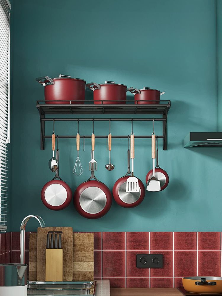 Red Non-stick pots hanging on a wall mounted pot rack
