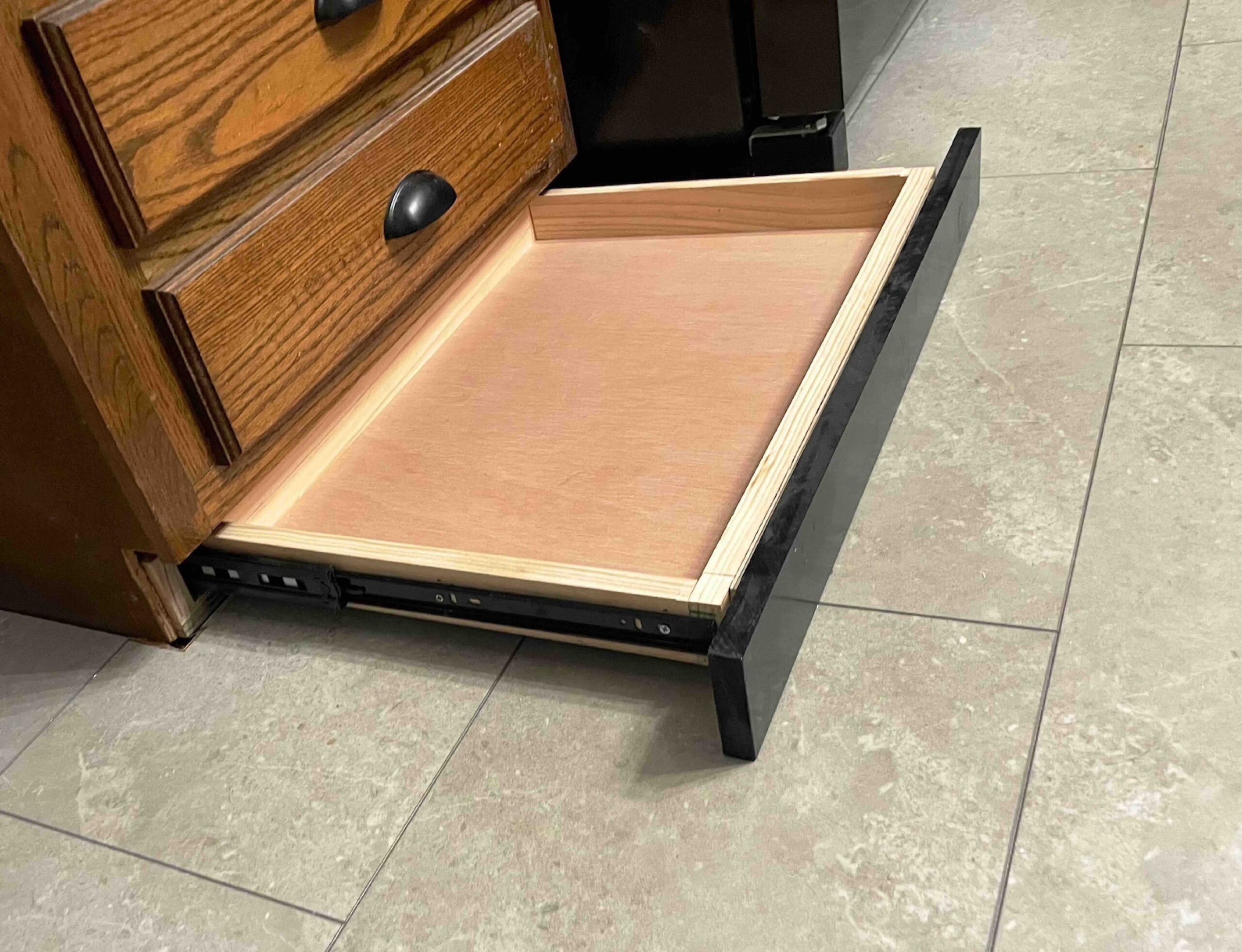Bottom drawer open in a toe kick drawer system