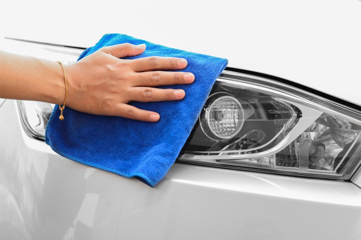 Hand wiping a microfiber cloth over a clean headlight