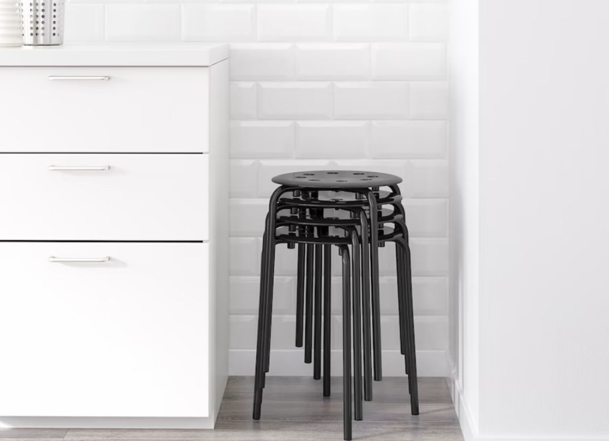 Stack of black plastic stools in the corner of the kitchen