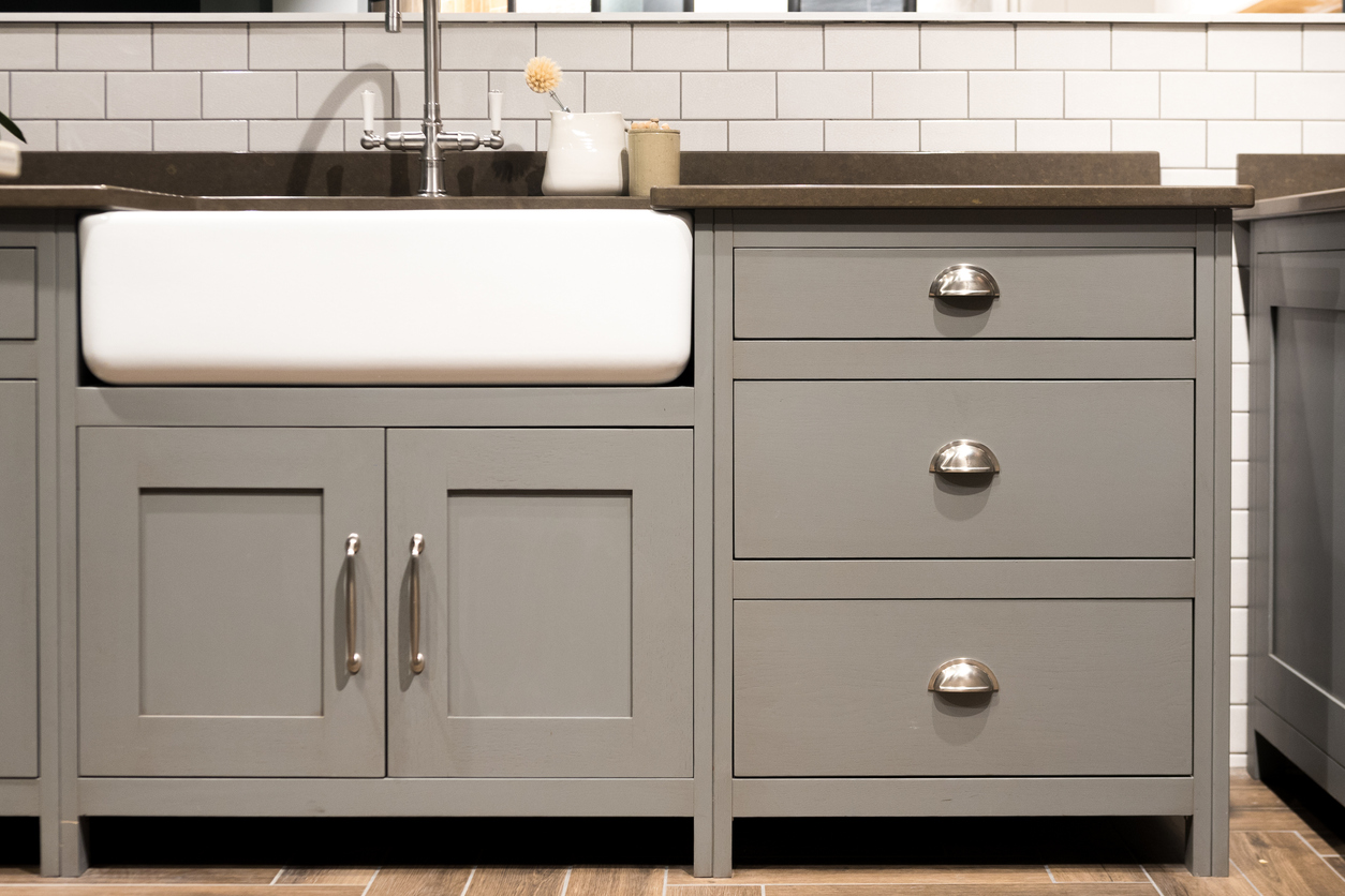 Gray kitchen base cabinets, including the under-sink cabinet and drawers