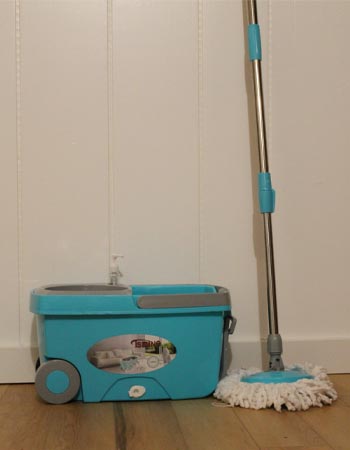 Tsmine Spin-Mop and Bucket leaning against white wainscoting