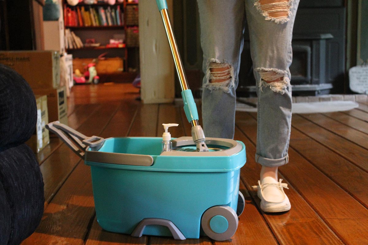 Person using spin mop to clean hardwood floor