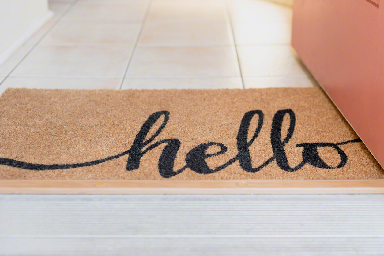 brown welcome mat that says hello in cursive