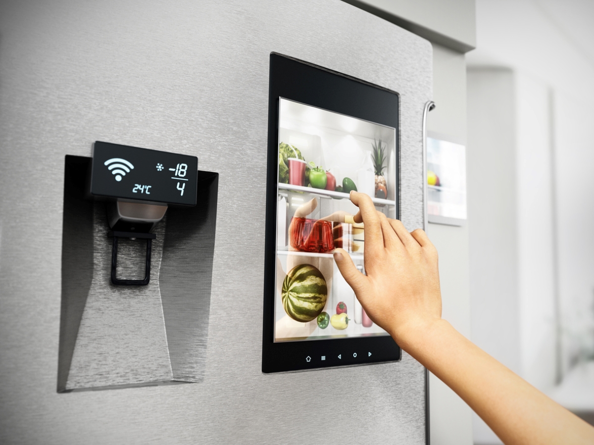 Person touching smart screen on fridge