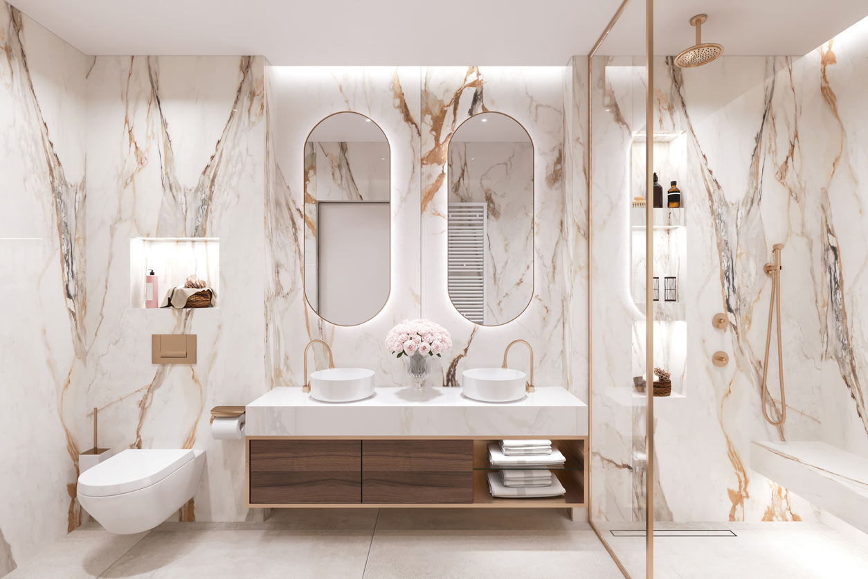 luxury bathroom designed with white and brown marble and gold lining with shower
