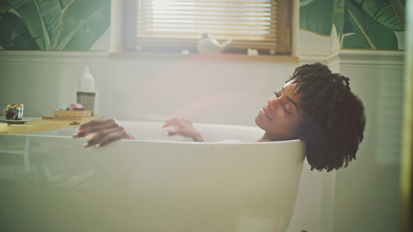 woman relaxing with eyes closed in the bathtub