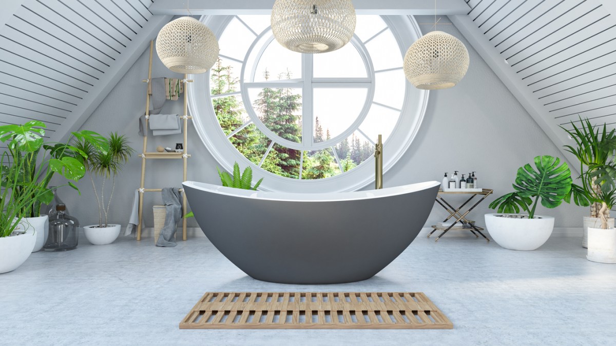 grey-bathtub-in-a-light-grey-bathroom-under-rattan-pendant-lights-and-in-front-of-a-large-round-window-with-trees
