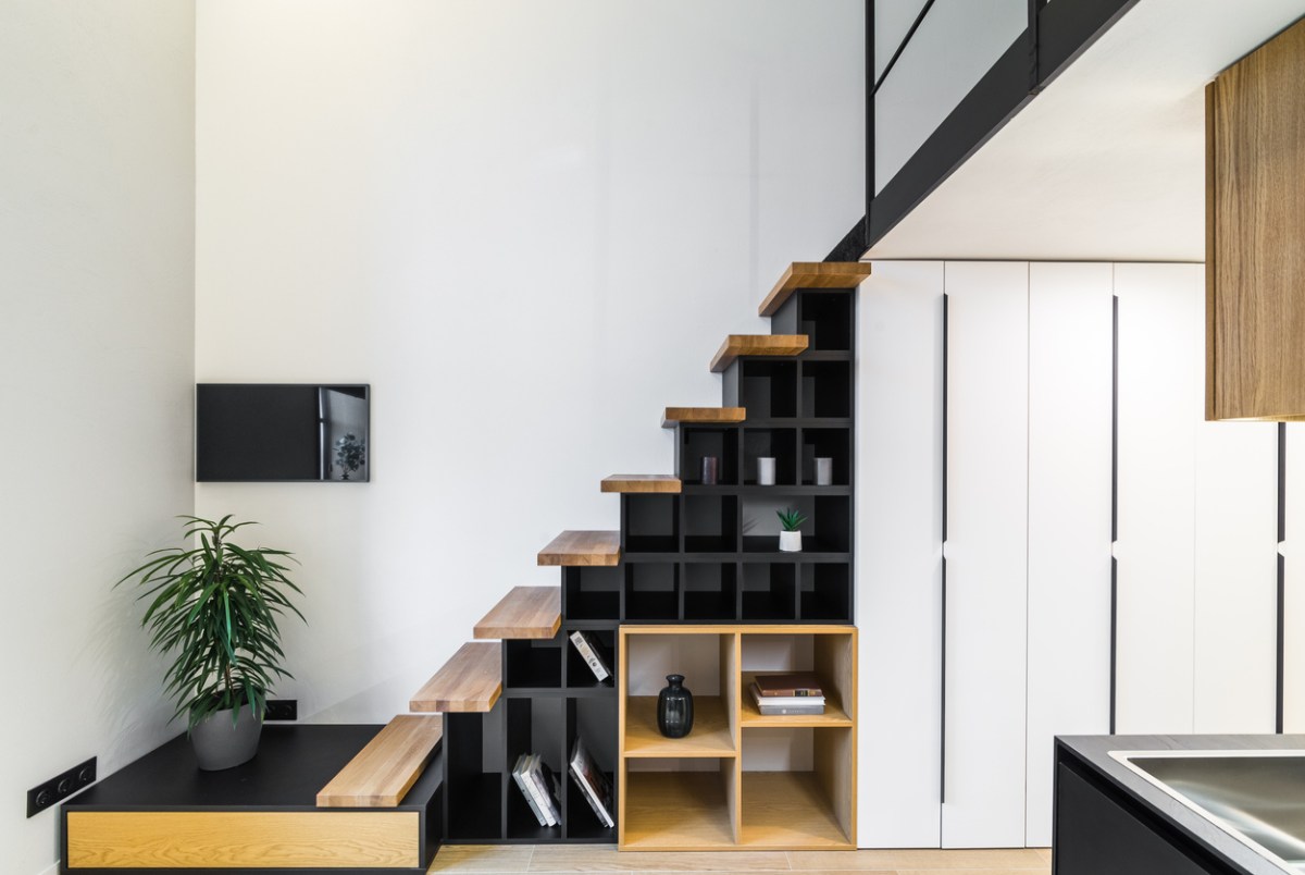 modern loft staircase with black and light colored wood square cubby hole shelving underneath