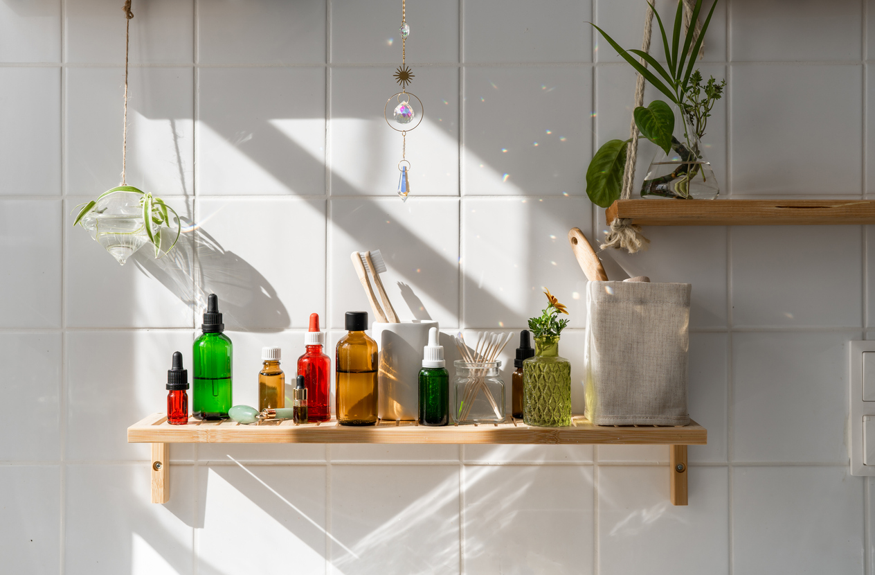 various beauty products on wood shelf on white tiled wall in the bathroom