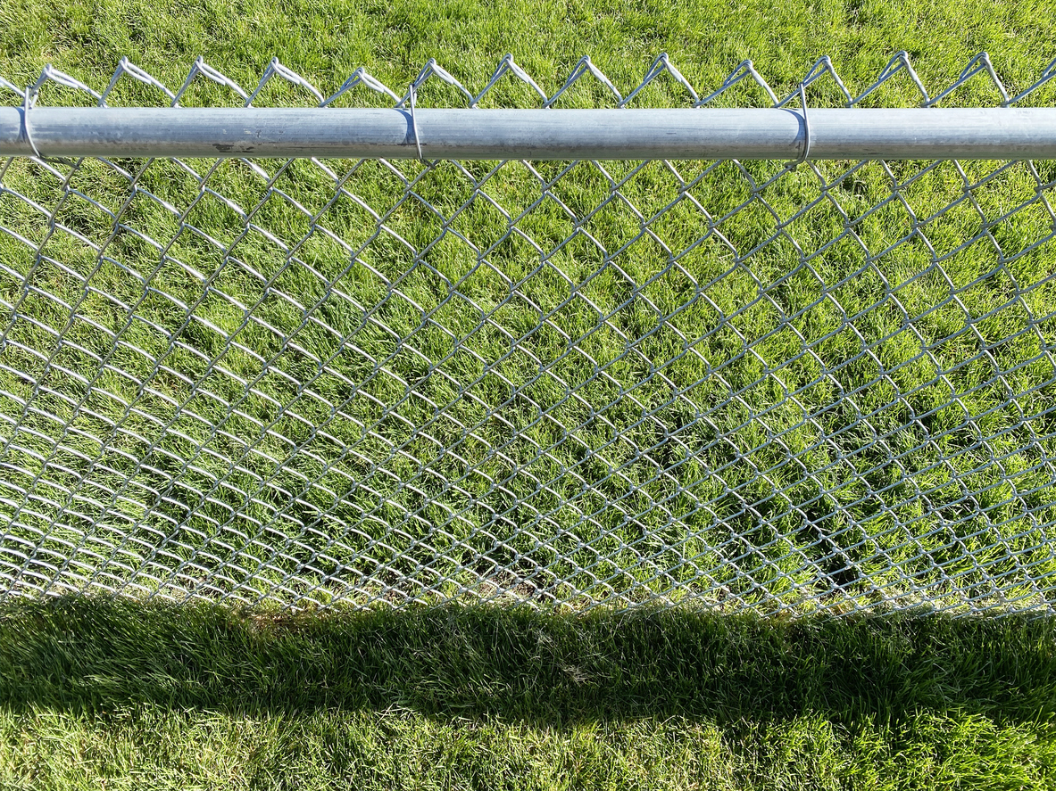 chain link fence installed in lush green lawn