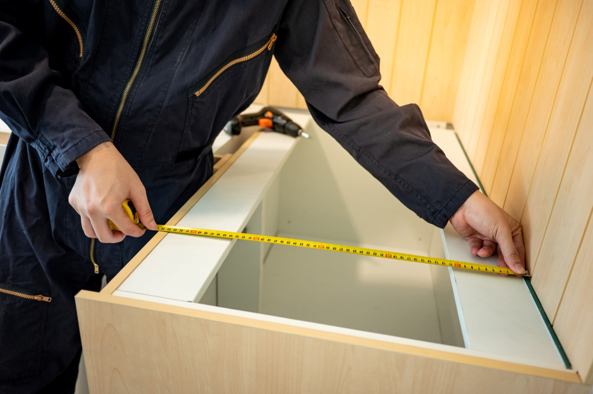 Person measuring kitchen cabinet depth
