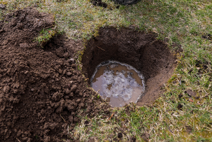 hole dug in soil with water