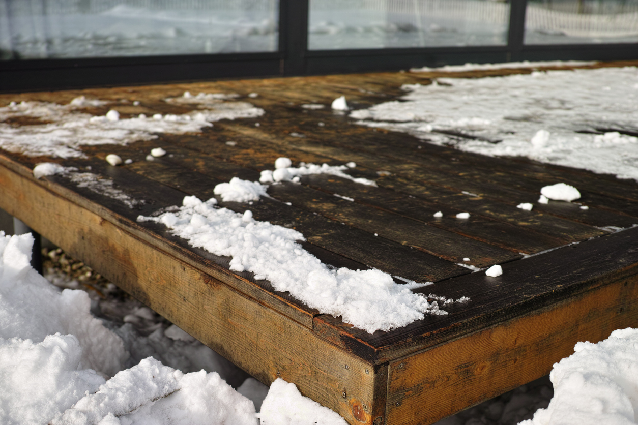 a-wooden-deck-with-ice-and-snow