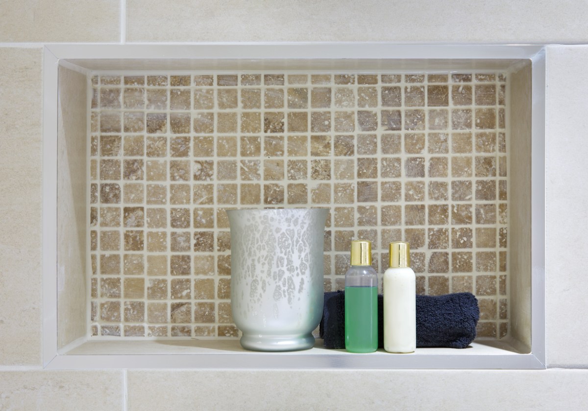 shower niche with beige tiles and small bottles of bath products