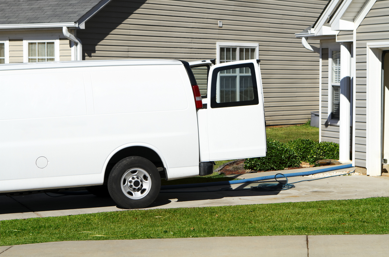 white work van in driveway of suburban home