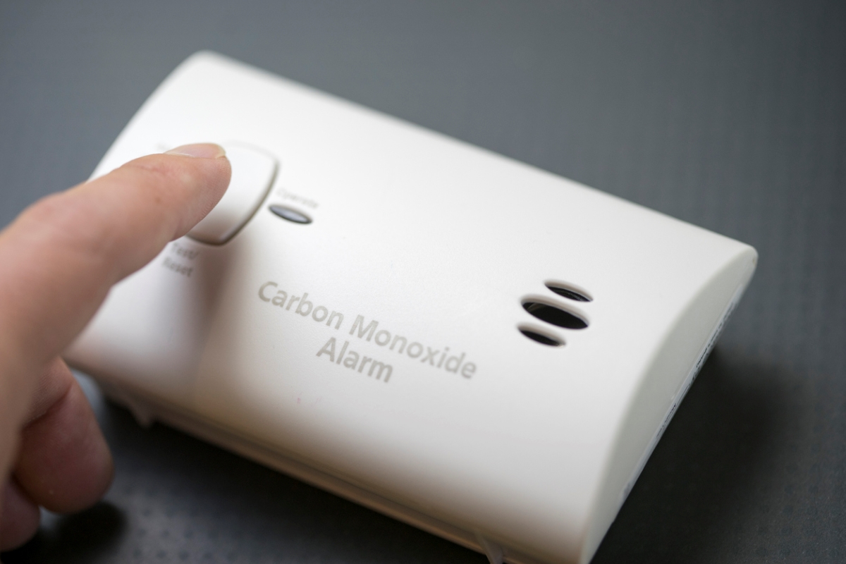 Pressing carbon monoxide detector button