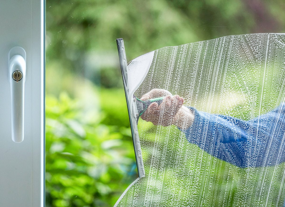 Person using squeegee to clean window