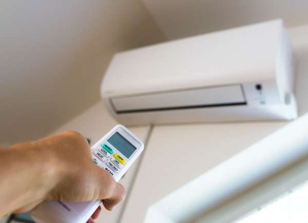 Person turning on ductless cooling unit