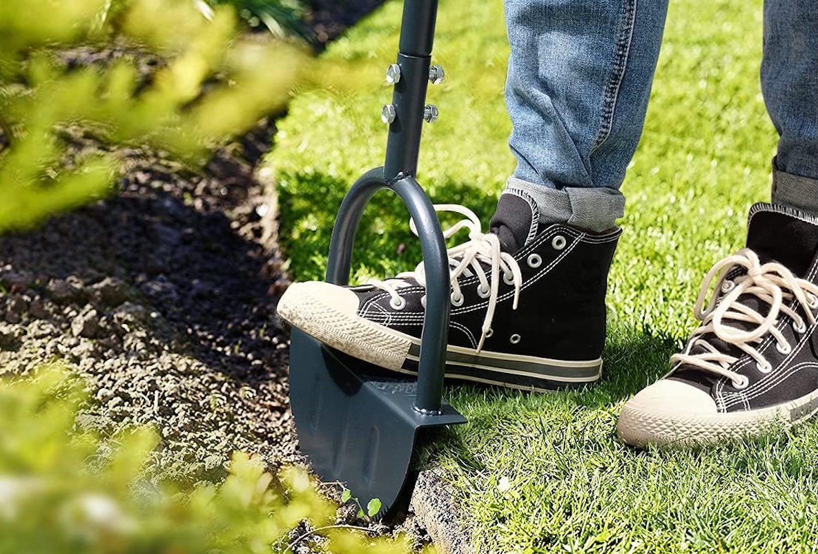 Colwelt edging shovel being used by a person wearing jeans and black Converse shoes.