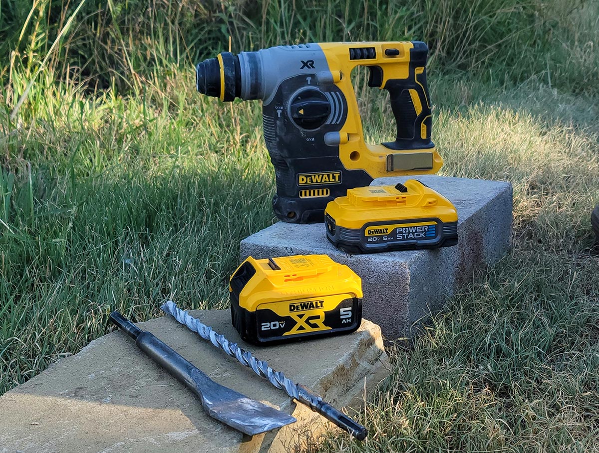 DeWalt PowerStack Batteries on a concrete block next to a DeWalt concrete drill