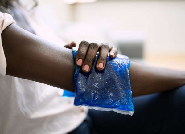 Black Woman applying ice pack to arm