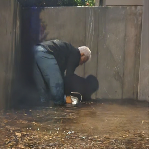 Man bailing water out of a flooded area