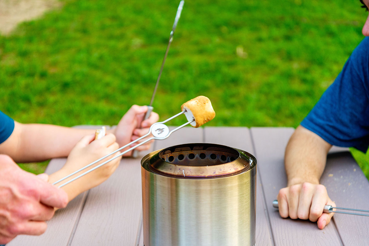 Children roasting marshmallows with the stainless steel mini roasting sticks that are part of the Solo Stove Mesa XL accessory kit