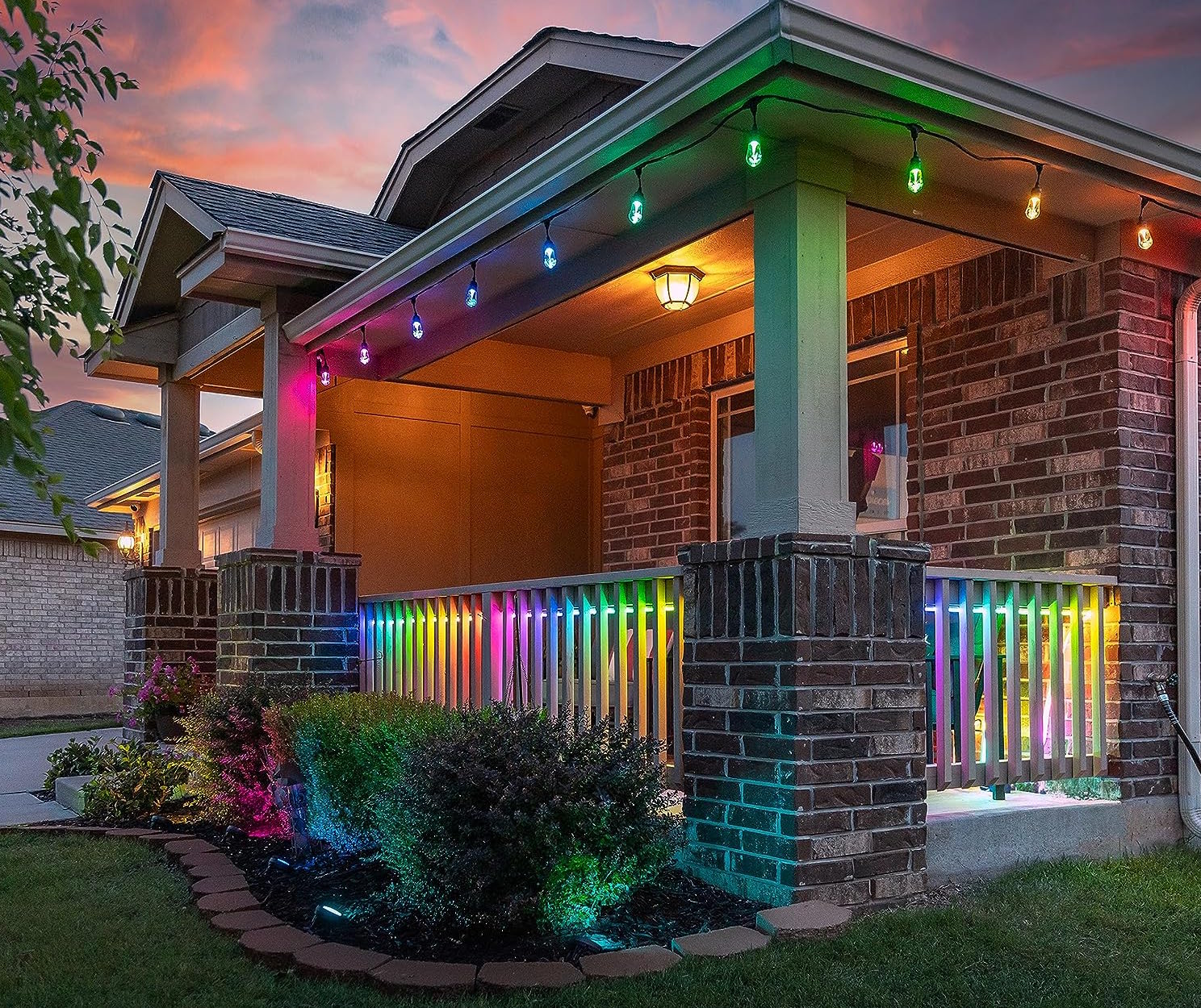 front of house with porch lit in rainbow colors by string lights