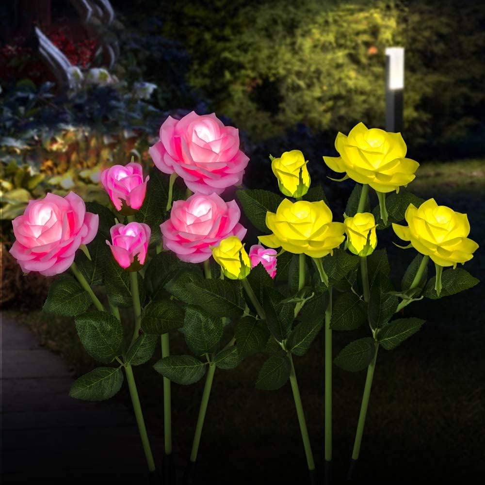 close view of pink and yellow rose shaped garden lights in garden at night