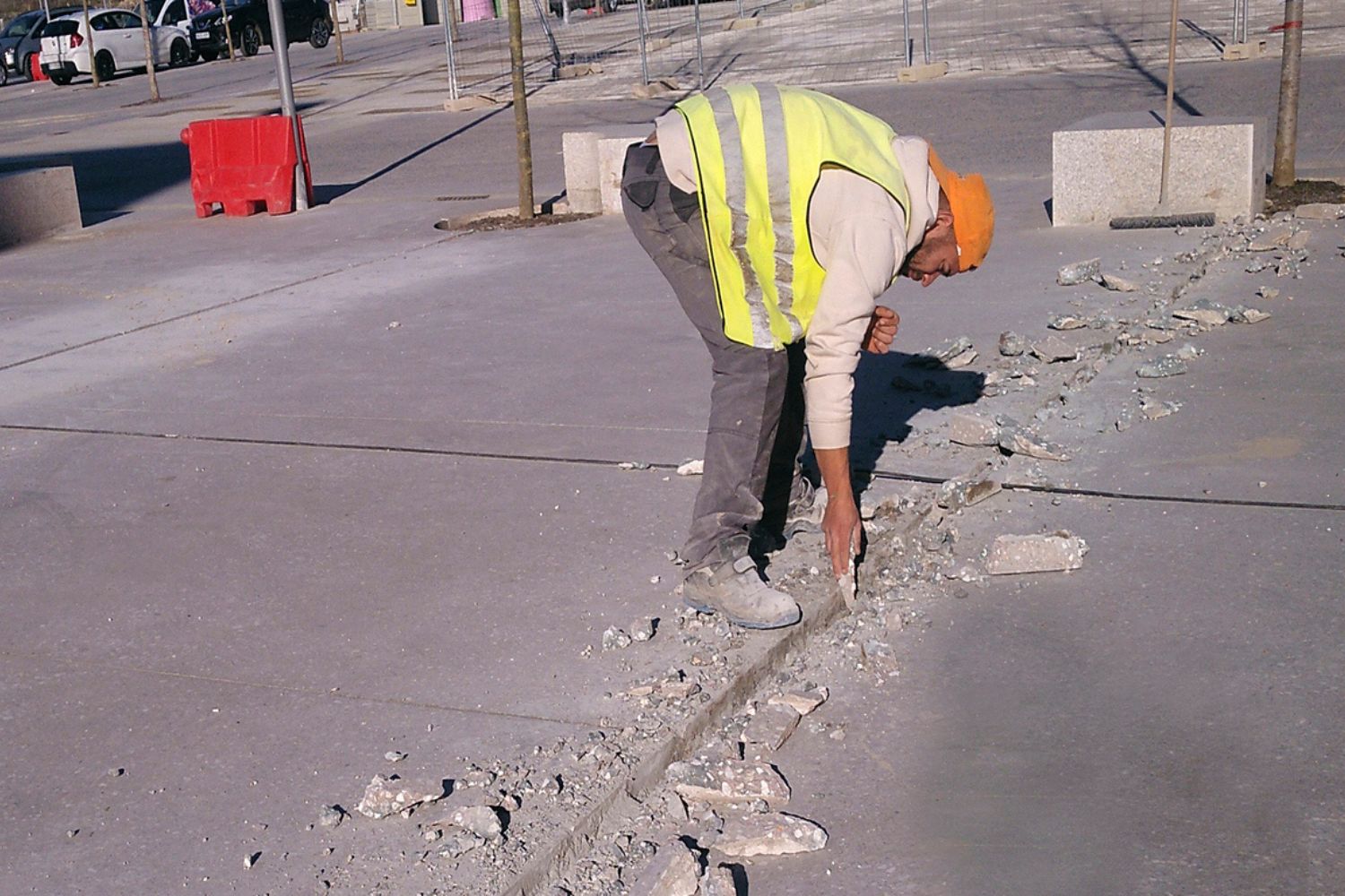 A worker scoring concrete while wearing the best work boots for concrete option