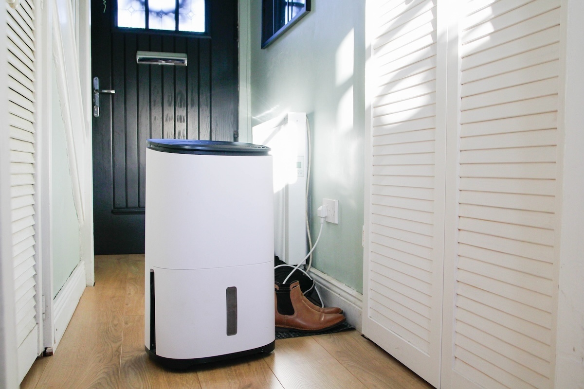 A white dehumidifier in a hallway.