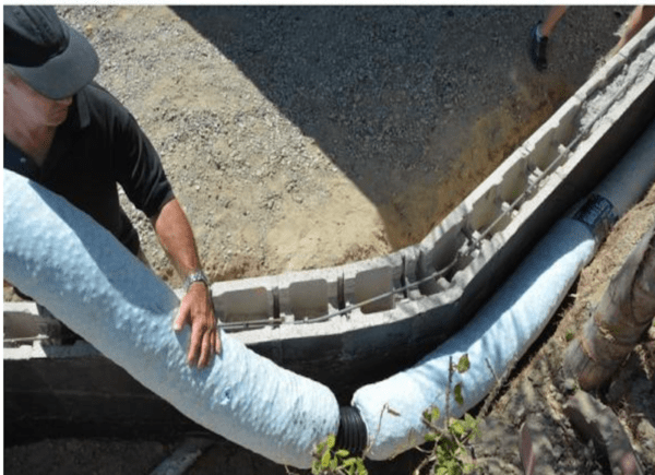 Man installing piping in a French drain
