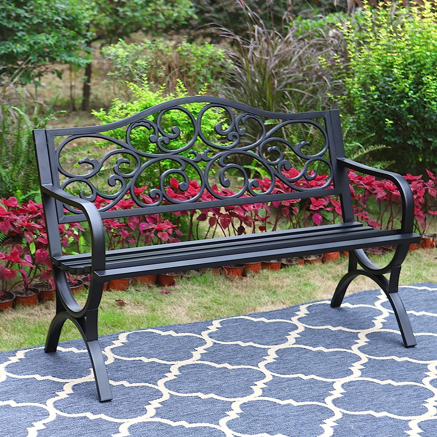 Classic cast iron garden bench on a geometric outdoor rug.