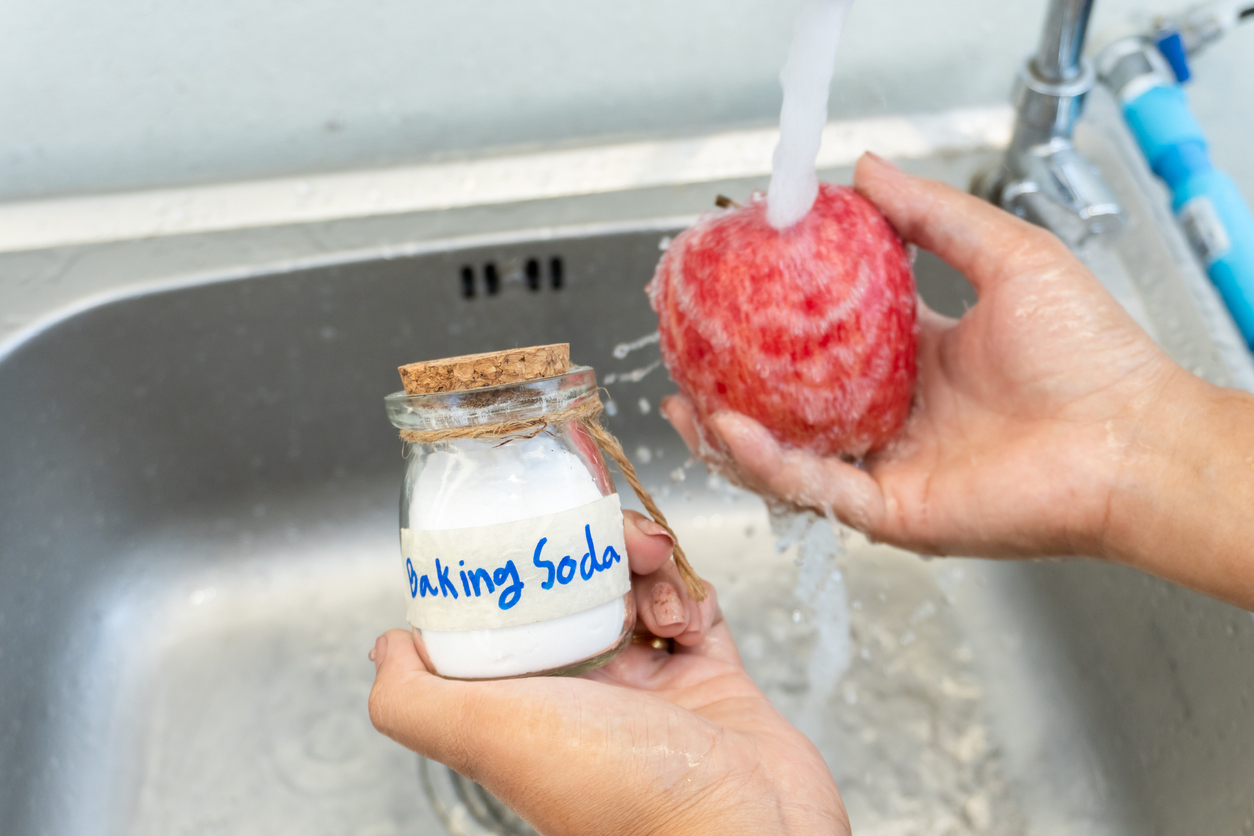 woman washing red apple with baking soda