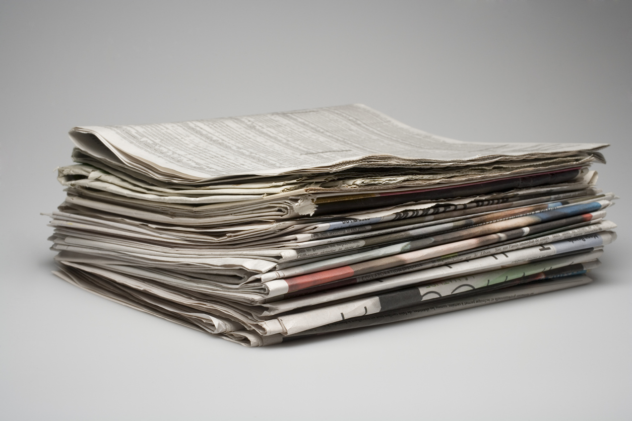 Stack of multiple sections of newspapers.