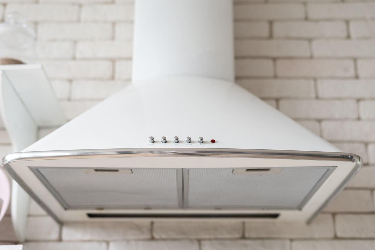 close up of white range hood with duct