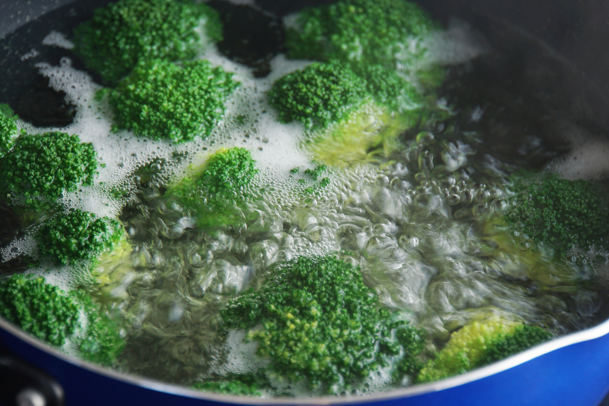 close view of broccoli boiling in large pot of hot water