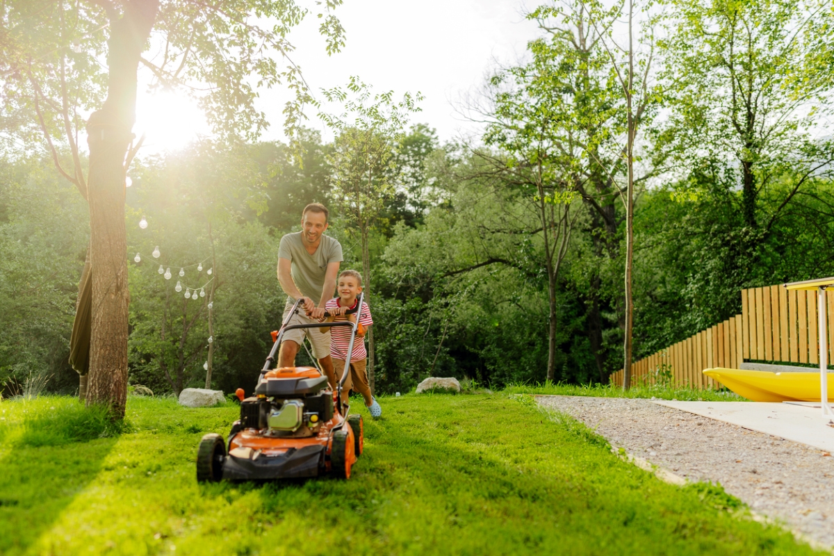 Father and son mowing grass