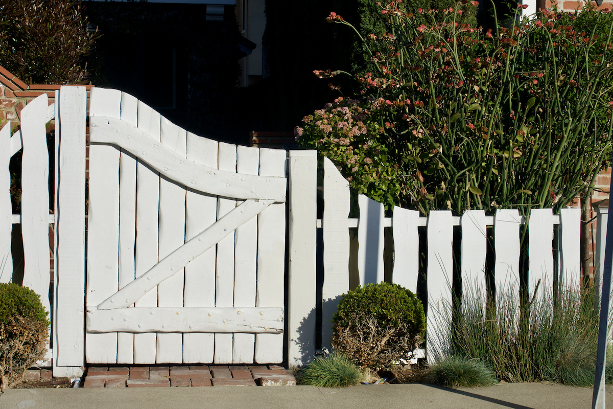 rustic white picket fence idea with wavy shape and boards