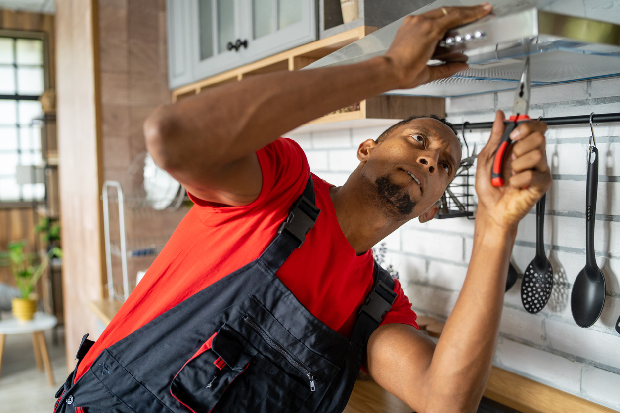 man-unscrews-the-filter-from-a-range-hood-in-the-kitchen